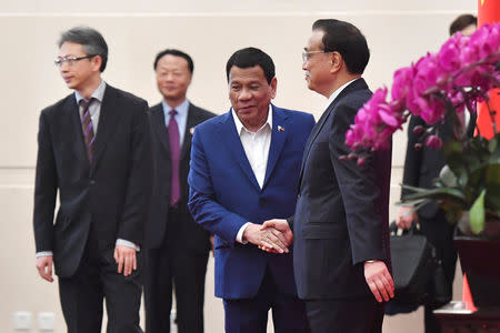 Philippine President Rodrigo Duterte approches to shake hands with Chinese Premier Li Keqiang at the Diaoyutai State Guesthouse in Beijing, China, April 25, 2019. Parker Song/Pool via REUTERS