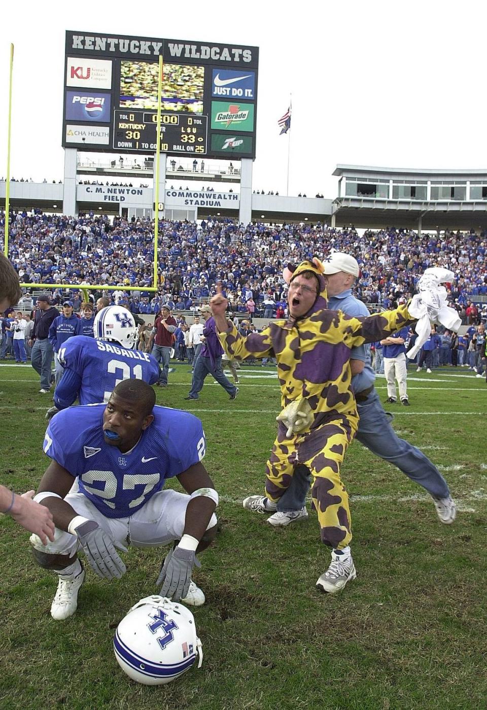 Chaos reigned on the Commonwealth Stadium turf after LSU’s “Bluegrass Miracle” victory over Kentucky in 2002. Many Kentucky fans stormed the field after what they believed was a UK upset of 16th-ranked LSU. In this memorable photo, LSU student Joey Herzog (cow costume) figured out his team was the victor just as he was bowled over by a UK fan on the field. Kentucky cornerback Leonard Burress calmly squatted and took in his surroundings in disbelief.