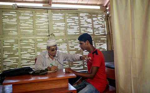 Dr Abdul Mazid checks a patient on a floating health clinic - Credit: Jack Taylor