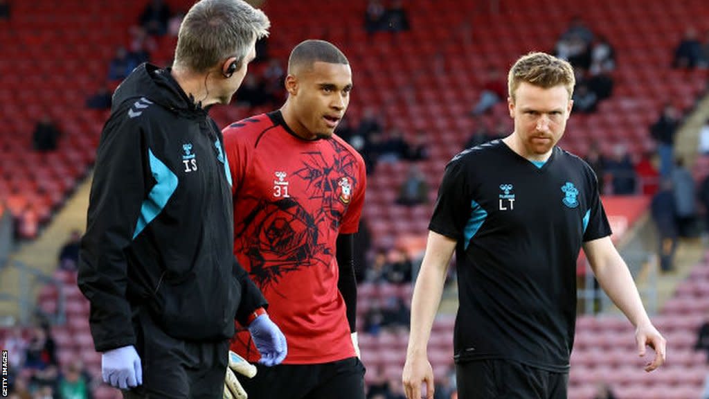 Gavin Bazunu limps off during the warm-up ahead of the game with Preston