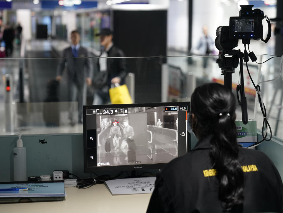 Health officials watch thermographic monitors at a quarantine inspection station at the Kuala Lumpur International Airport in Sepang, Malaysia, Tuesday, Jan. 21, 2020. Countries both in the Asia-Pacific and elsewhere have initiated body temperature checks at airports, railway stations and along highways in hopes of catching those at risk of carrying a new coronavirus that has sickened more than 200 people in China. (AP Photo/Vincent Thian)