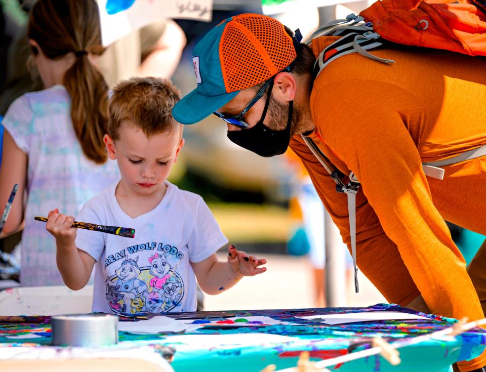 David Adams works on an art project with his son Thad, 3, during the Paseo Arts Festival in Oklahoma City, Okla. on Monday, Sept. 6, 2021. 