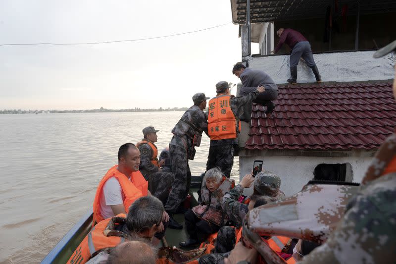 Soldiers of the PLA evacuate residents stranded by floodwaters with a boat in Luan