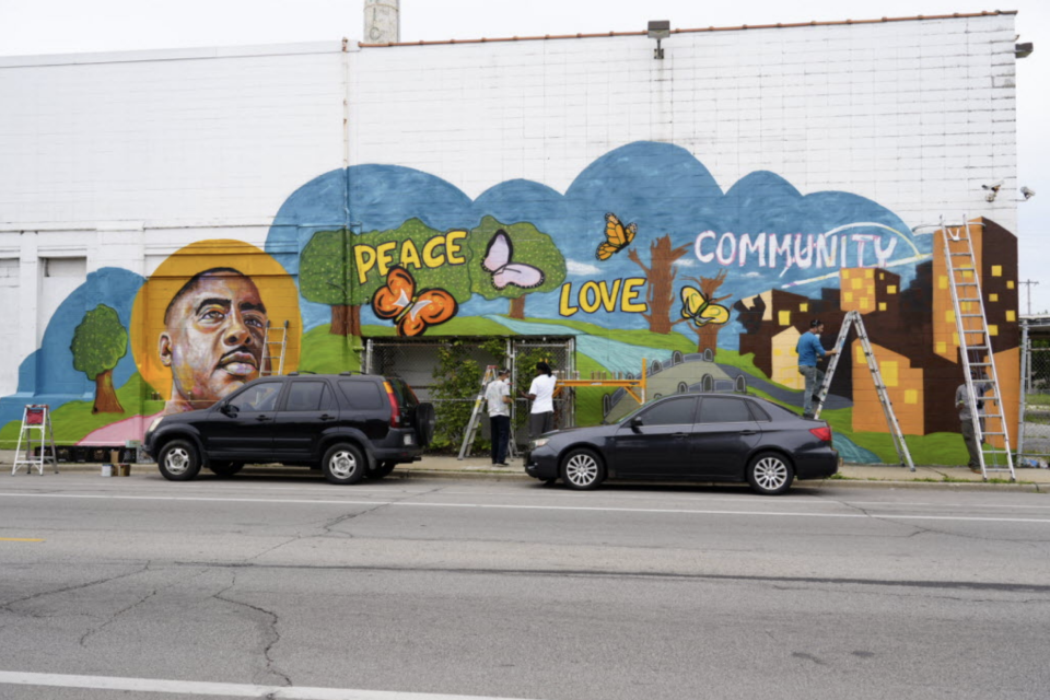 Artists paint a mural on a building owned Hayat Pharmacy at 1003 W. North Ave.