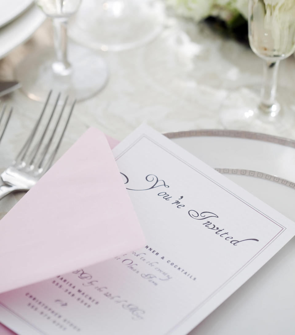 Wedding invitation on table setting. (Jamie Grill / Getty Images)