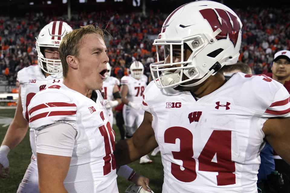 Wisconsin quarterback Braedyn Locke, left, celebrates with running back Jackson Acker the team's come from behind win over Illinois after an NCAA college football game Saturday, Oct. 21, 2023, in Champaign, Ill. (AP Photo/Charles Rex Arbogast)