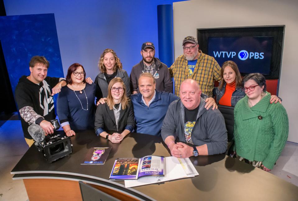 New WTVP board chairman John Wieland, cener in blue shirt, poses with members of the public television station's staff including producer Kayla Hallowell, left of Wieland, senior content producer Mark Welp, right of Wieland, and from left to right in the back row, senior producer Todd Pilon, interim station manager Julie Sanders, producer Amy Arhart, program manager Jed Klabunde, traffic manager Bryan Wolford, corporate support manager Angie Spears and development executive Genevieve Ferrel, in their studio in downtown Peoria.