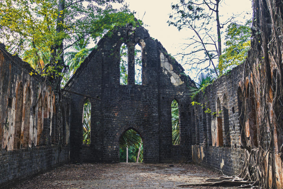 Ruins of abandoned Old British building covered with roots at Ross Island, Andaman Nicobar Islands, India