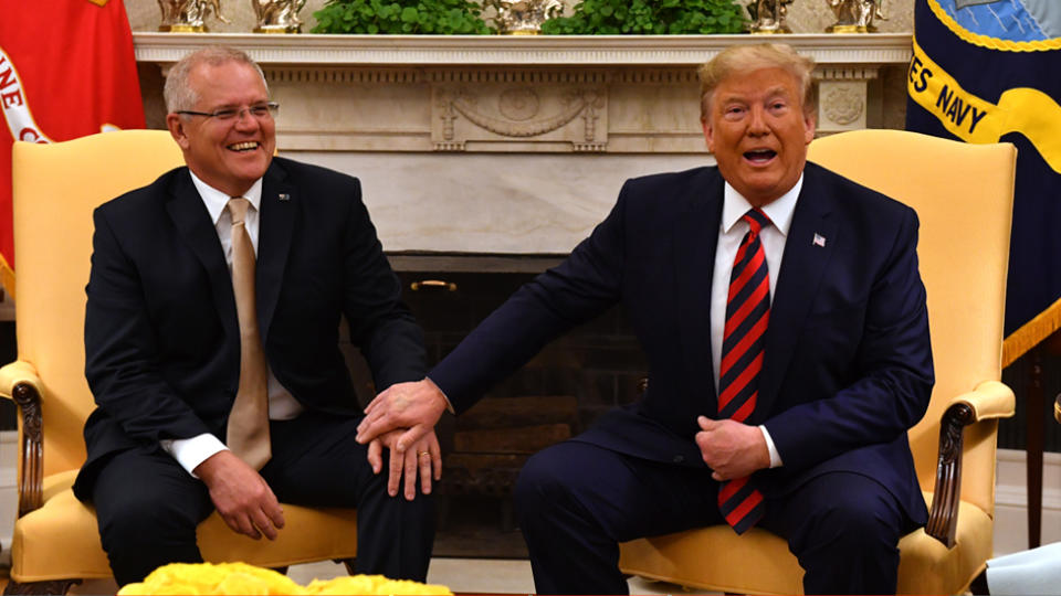 Donald Trump puts his hand on top of Scott Morrison's during a press call at the White House.