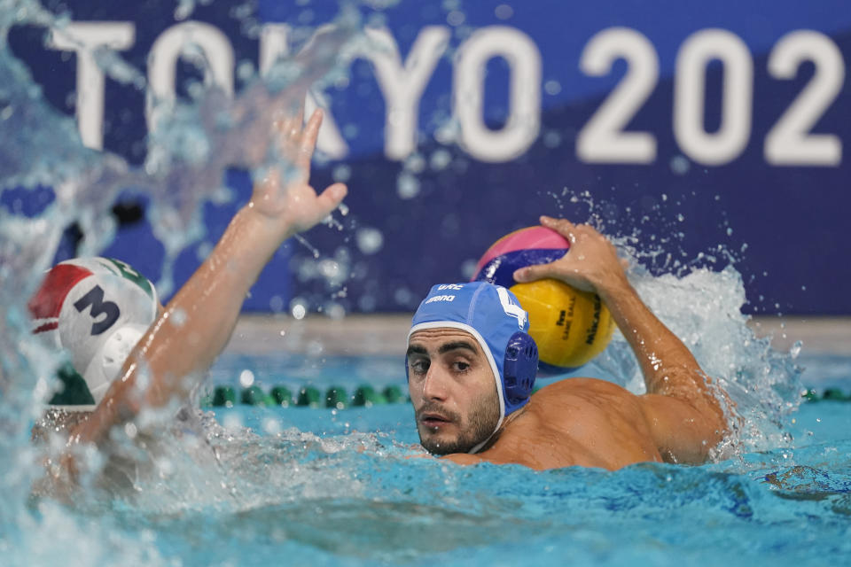 Greece's Marios Kapotsis (4) looks for a teammate past Hungary's Krisztian Manhercz (3) during a preliminary round men's water polo match at the 2020 Summer Olympics, Sunday, July 25, 2021, in Tokyo, Japan. (AP Photo/Mark Humphrey)