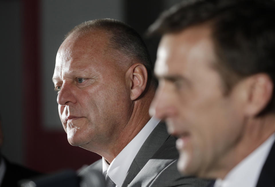 Gerard Gallant, left, listens to Vegas Golden Knights general manager George McPhee, right, speak during a news conference Thursday, April 13, 2017, in Las Vegas. The Vegas Golden Knights have hired Gallant as the first coach of the NHL expansion team. (AP Photo/John Locher)