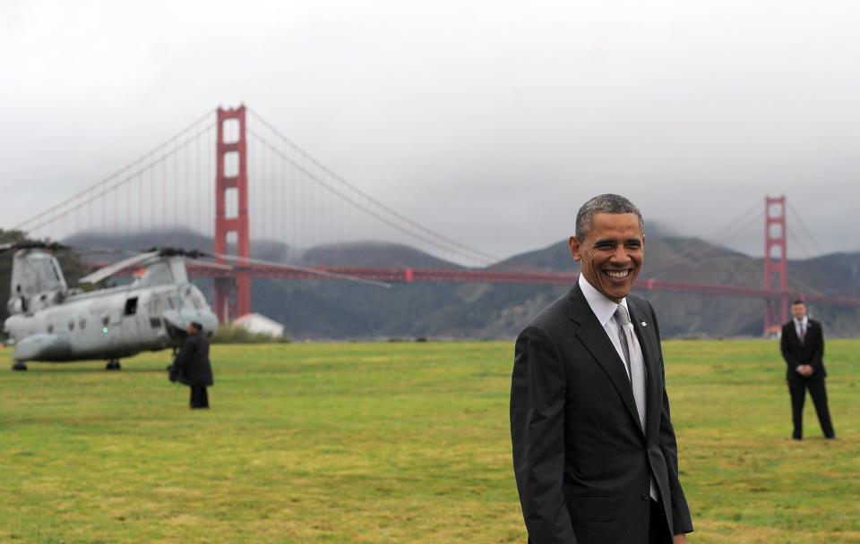 President Barack Obama smiles before boarding Marine One helicopter from a field overlooking the iconic Golden Gate Bridge in San Francisco, California, on April 4, 2013. Obama was in California to attend two DCCC fundraising events.