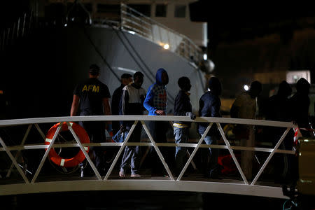 FILE PHOTO: Migrants, part of a group of 69 migrants rescued 117 nautical miles south west of Malta, disembark from an Armed Forces of Malta patrol boat after it arrived at its base in Valletta's Marsamxett Harbour, Malta December 30, 2018. REUTERS/Darrin Zammit Lupi