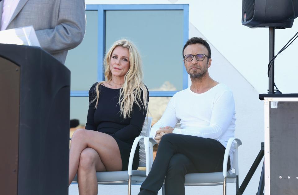 Britney Spears and talent manager Larry Rudolph listen to Clark County Commissioner Steve Sisolak's speech during the grand opening of the Nevada Childhood Cancer Foundation Britney Spears Campus on Nov. 4, 2017, in Las Vegas.