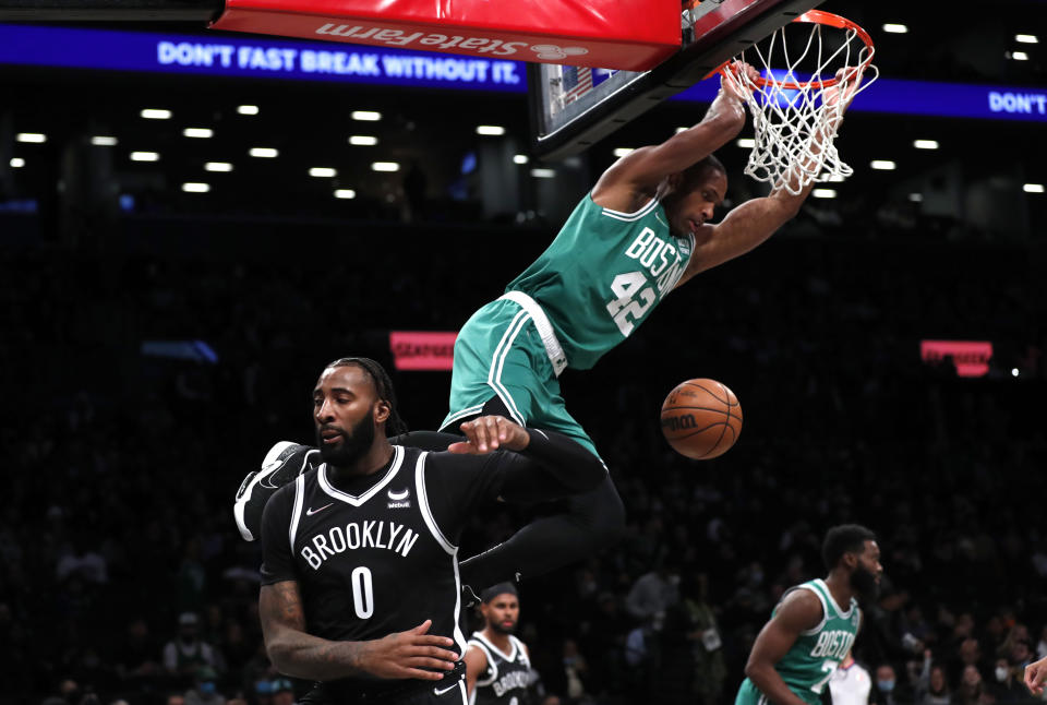 Boston Celtics center Al Horford (42) dunks against Brooklyn Nets center Andre Drummond (0) during the first half of an NBA basketball game Thursday, Feb. 24, 2022, in New York. (AP Photo/Noah K. Murray)