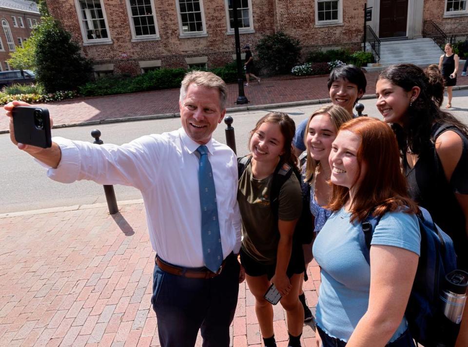 UNC-Chapel Hill Chancellor Kevin Guskiewicz takes a selfie with students near the Old Well on the first day of classes in Chapel Hill, N.C. on Monday, Aug. 21, 2023.