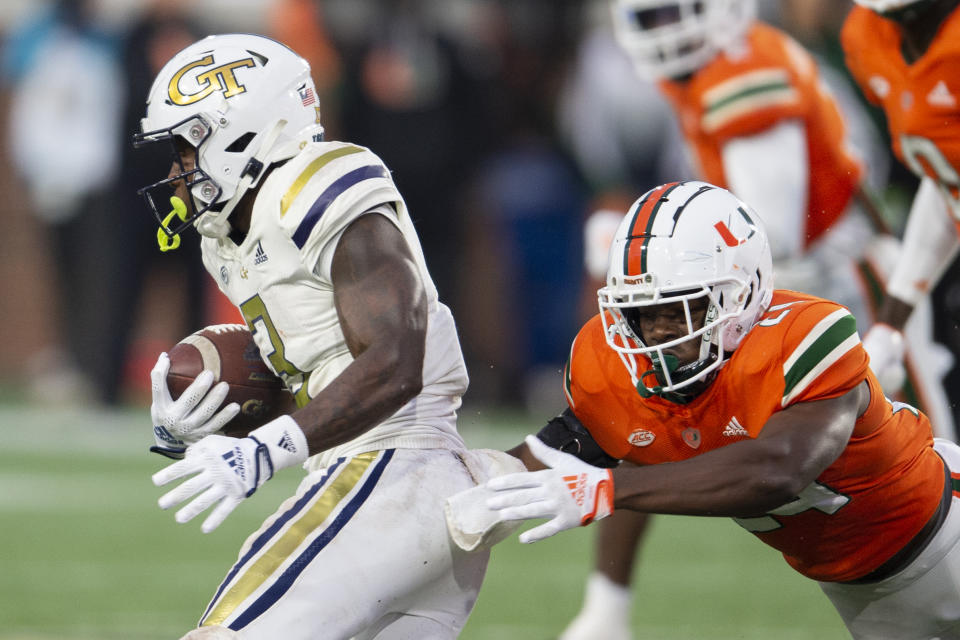 Georgia Tech running back Hassan Hall avoids tackle by Miami safety Kamren Kinchens in the second half of an NCAA college football game Saturday, Nov. 12, 2022, in Atlanta. (AP Photo/Hakim Wright Sr.)