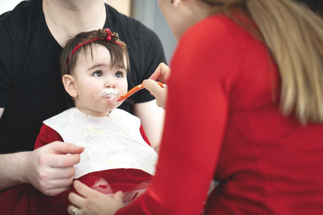 Parent feeding their little baby