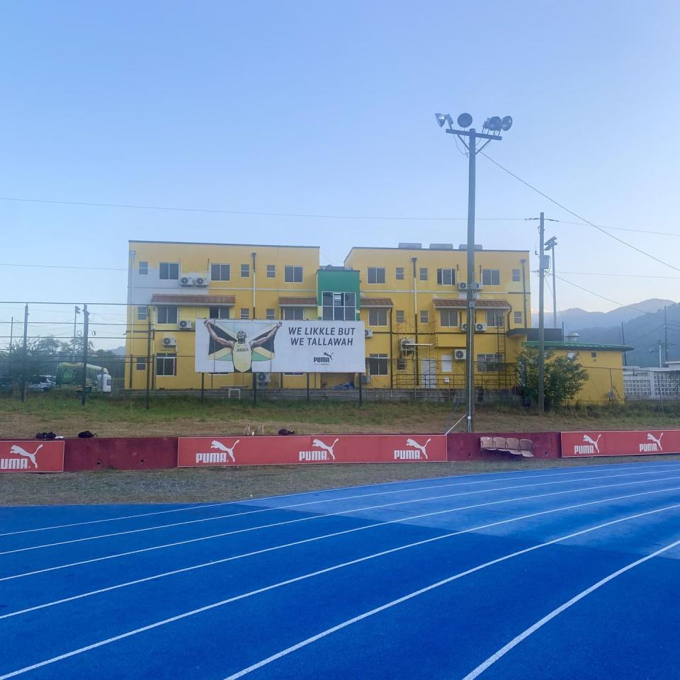 a tennis court with a large building in the background