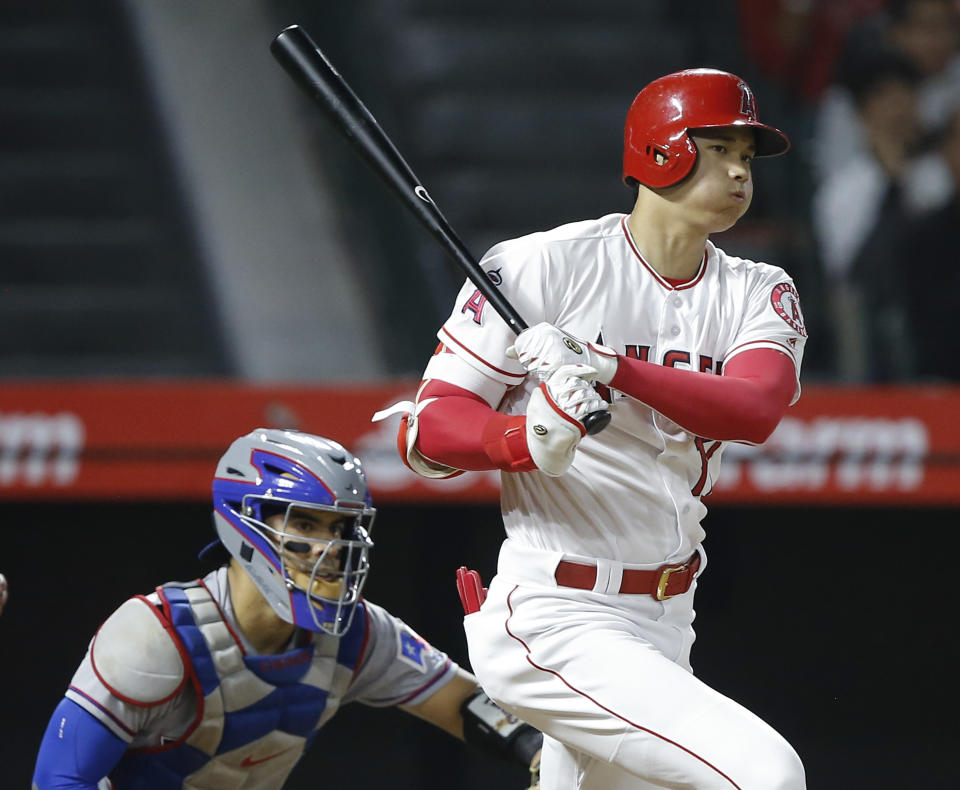 Los Angeles Angels designated hitter Shohei Ohtani watches his RBI single next to Texas Rangers catcher Robinson Chirinos during the fourth inning of a baseball game in Anaheim, Calif., Wednesday, Sept. 26, 2018. (AP Photo/Alex Gallardo)