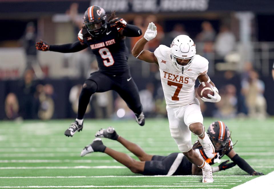 Texas’ Keilan Robinson (7) gets by Oklahoma State’s Trey Rucker (9) and Kale Smith (10) on a touchdown run in the second half of the Big 12 Football Championship game between the Oklahoma State University Cowboys and the <a class="link " href="https://sports.yahoo.com/ncaaf/teams/texas/" data-i13n="sec:content-canvas;subsec:anchor_text;elm:context_link" data-ylk="slk:Texas Longhorns;sec:content-canvas;subsec:anchor_text;elm:context_link;itc:0">Texas Longhorns</a> at the AT&T Stadium in Arlington, Texas, Saturday, Dec. 2, 2023.