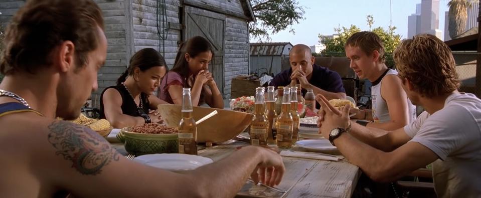 The "Fast and the Furious" cast gather around a table to eat at the end of the first movie.