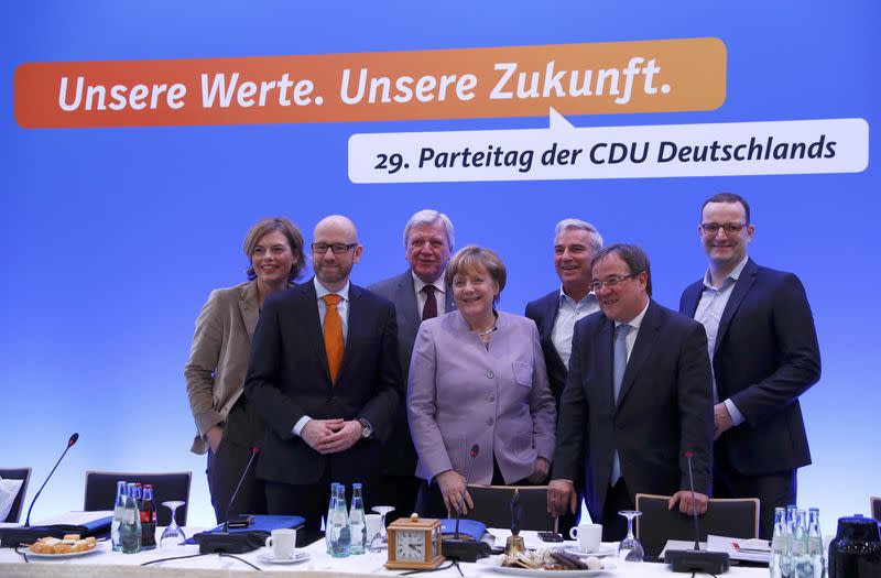 La chancelière allemande avec des autres chefs du parti conservative CDU au congrès de ce parti à Essen, en Rhénanie-du-Nord-Westphalie. Merkel, candidate à un quatrième mandat, y tentera mardi de resserrer les rangs des chrétiens démocrates lors du congrès de la CDU, à l'approche de l'élection fédérale de septembre qu'elle prévoit "difficile comme aucune autre". /Photo prise le 5 décembre 2016/REUTERS/Wolfgang Rattay