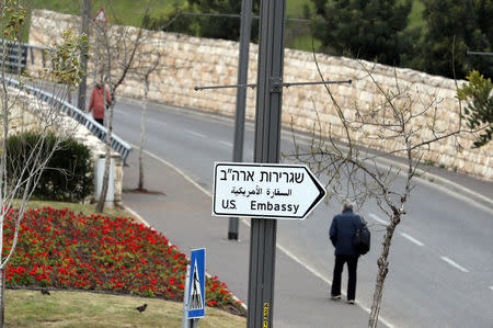 A man walks next to a road sign directing to the U.S. embassy in Jerusalem, February 18, 2019. Picture taken February 18, 2019 REUTERS/Ammar Awad