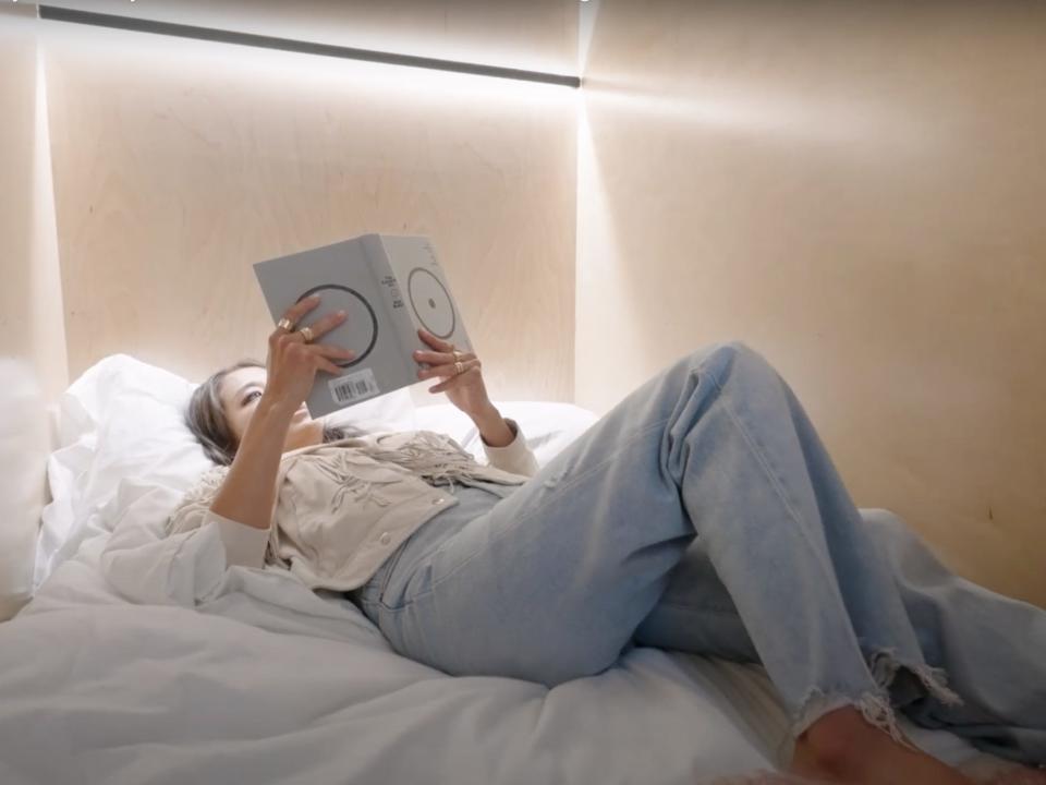 Sung Yoo reading a book whilst lying in her bedroom cove.