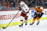 Carolina Hurricanes' Jaccob Slavin, left, tries to keep away from Philadelphia Flyers' Sean Couturier during the second period of an NHL hockey game, Thursday, March 5, 2020, in Philadelphia. (AP Photo/Matt Slocum)