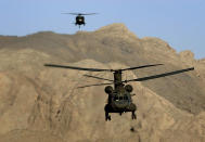 FILE - In this March 27, 2004 file photo, Chinook helicopters fly over the Paktia's mountains province near Khost, about 200 kilometers (120 miles) southeast of Kabul, Afghanistan. After 20 years of military engagement and billions of dollars spent, NATO and the United States still grapple with the same, seemingly intractable conundrum — how to withdraw troops from Afghanistan without abandoning the country to even more mayhem. (AP Photo/Emilio Morenatti, File)