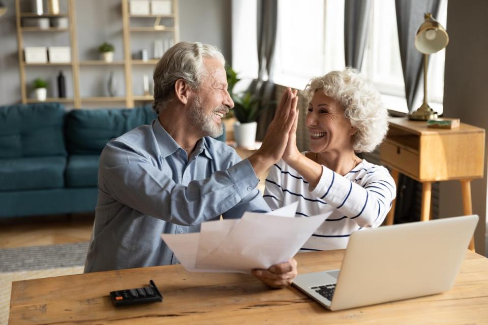 Two people at a computer high-fiving.