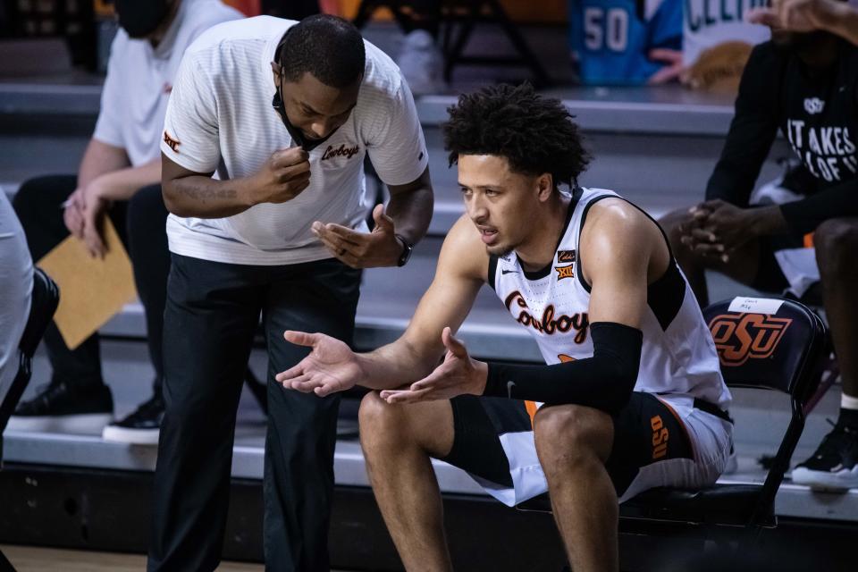 Oklahoma State coach Mike Boynton talks with guard Cade Cunningham during the game against the Texas on Feb. 6, 2021 in Stillwater, Okla.