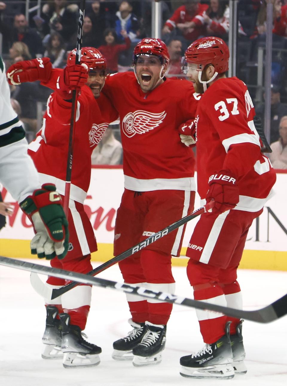 Detroit Red Wings left wing David Perron, center, celebrates his goal against the Minnesota Wild with defenseman Shayne Gostisbehere (41) and left wing J.T. Compher (37) during the first period of an NHL hockey game Sunday, Nov. 26, 2023, in Detroit. (AP Photo/Duane Burleson)