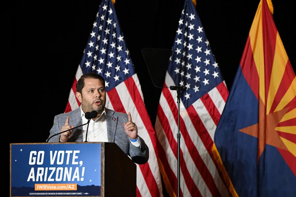 Ruben Gallego stands at a podium with plaque that reads: Go vote, Arizona!