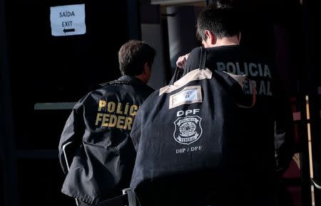 A federal police officer carries a pouch as he arrives at the Federal Police headquarters in Sao Paulo, Brazil June 21, 2018. REUTERS/Leonardo Benassatto