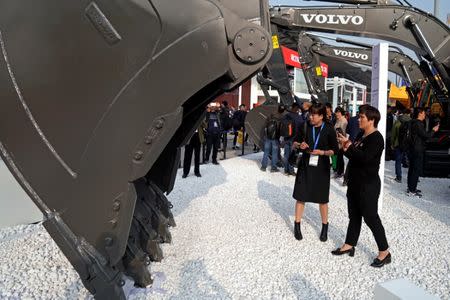 FILE PHOTO: People visit heavy machinery of Volvo at Bauma China, the International Trade Fair for Construction Machinery in Shanghai, China November 27, 2018. REUTERS/Aly Song