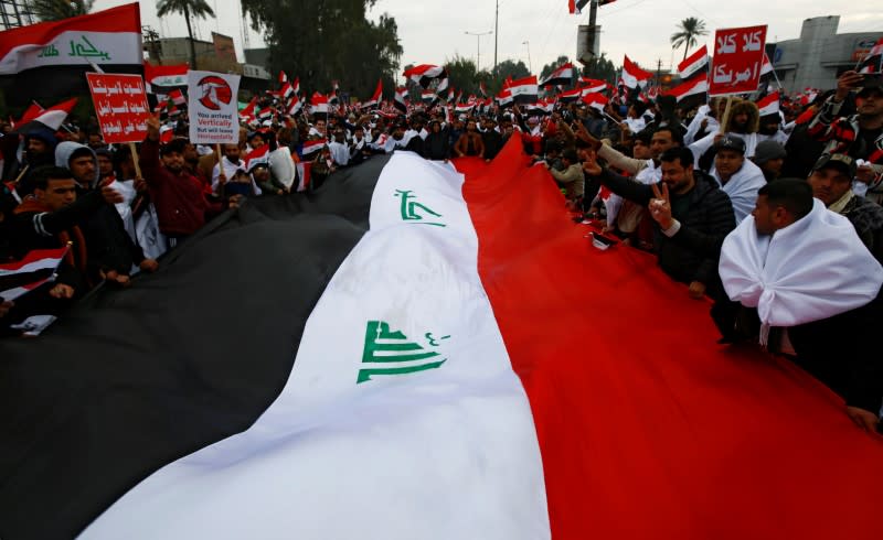 Supporters of Iraqi Shi'ite cleric Moqtada al-Sadr carry a huge Iraqi flag at a protest against what they say is U.S. presence and violations in Iraq, in Baghdad