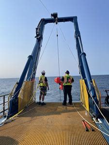 The research team uses the custom built Hawboldt crane to deploy and test the SeaCycler's new carbon-focused mooring.Photo credits – Dr. Dariia Atamanchuk (L) and Jenni Tolman (R