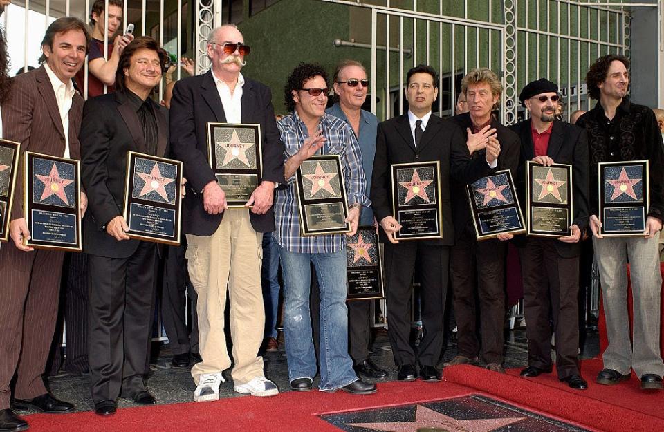 (L-R) Rock group Journey bandmembers Jonathan Cain, Steve Perry, George Tickner, Neal Schon, Aynsley Dunbar (rear), Robert Fleischman, Ross Valory, and Steve Smith (beret) at their star ceremony where they were honored on the Hollywood Walk of Fame.