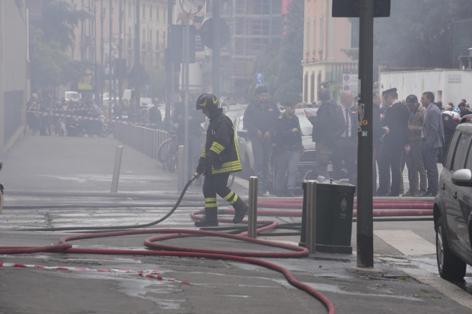 Firefighters work to extinguish a fire in a building after a van exploded in central Milan, northern Italy, Thursday, May 11, 2023. (AP Photo/Luca Bruno)