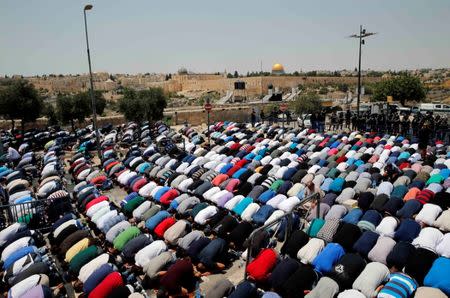 Palestinians pray on a street near a road block outside Jerusalem's Old City July 21, 2017. REUTERS/Ammar Awad