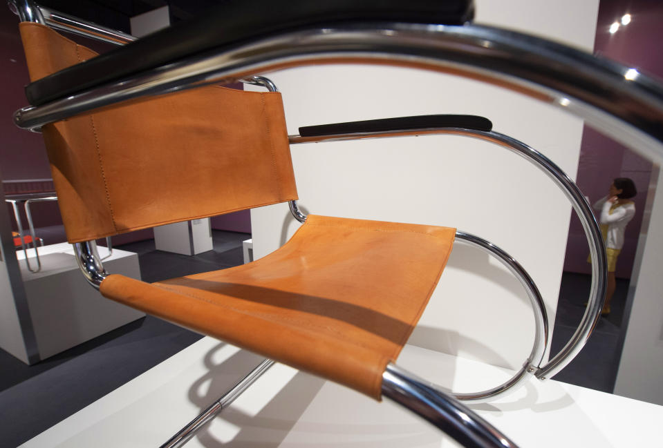 A woman stands behind an armchair (Design 1927) in one of the exhibition halls during the press preview of the new Bauhaus Museum in Dessau, Germany, Saturday, Sept. 7, 2019. The collection of the Bauhaus Dessau Foundation comprises around 49,000 catalogued exhibits and is the second-largest collection worldwide on the theme of the Bauhaus. The official opening of the new Bauhaus Museum, built for the centenary of the founding of the Bauhaus, will take place on Sunday, Sept. 8, 2019. (AP Photo/Jens Meyer)