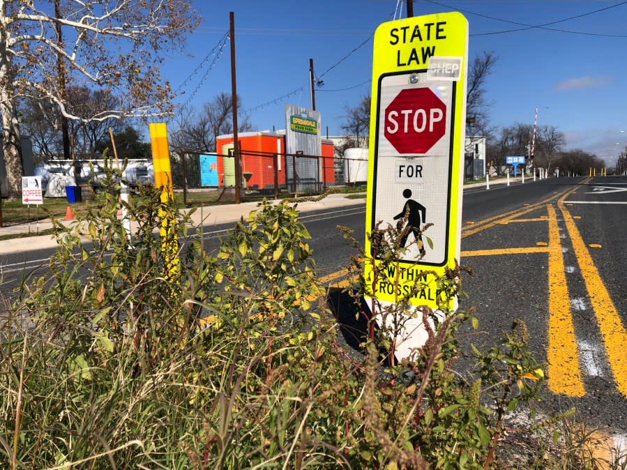 Signs posted in the 900 block of Springdale Road in Austin alerting drivers to stop for pedestrians and cyclist within the crosswalk. (KXAN Photo/Arezow Doost)