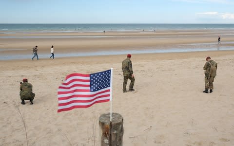 The scene in Colleville-sur-Mer as soldiers walk on the beach during the D-Day celebrations - Credit: Sean Gallup/Getty Images