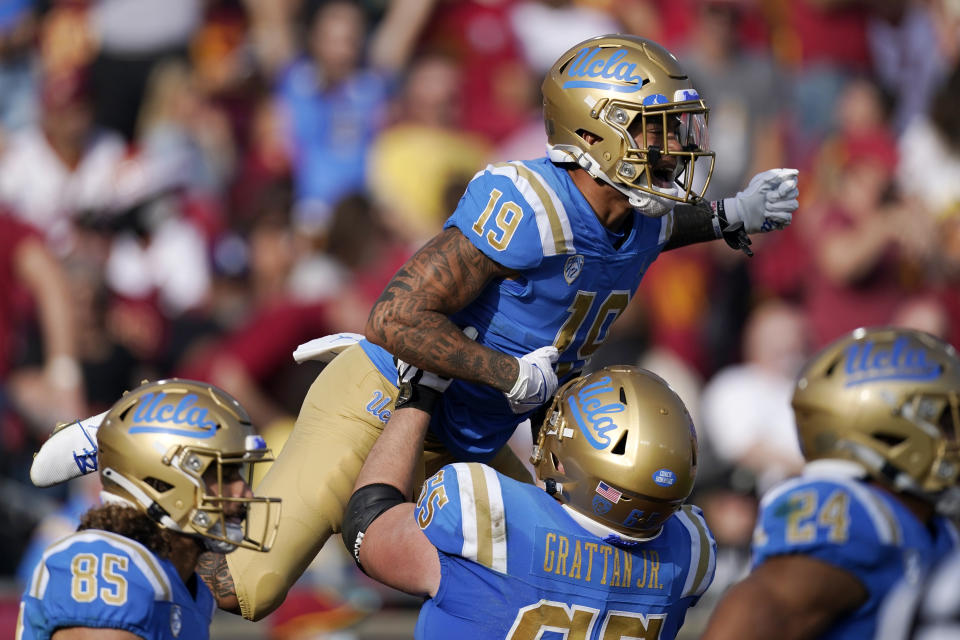 UCLA running back Kazmeir Allen, top, celebrates with offensive lineman Paul Grattan after scoring a touchdown during the first half of an NCAA college football game against Southern California Saturday, Nov. 20, 2021, in Los Angeles. (AP Photo/Mark J. Terrill)