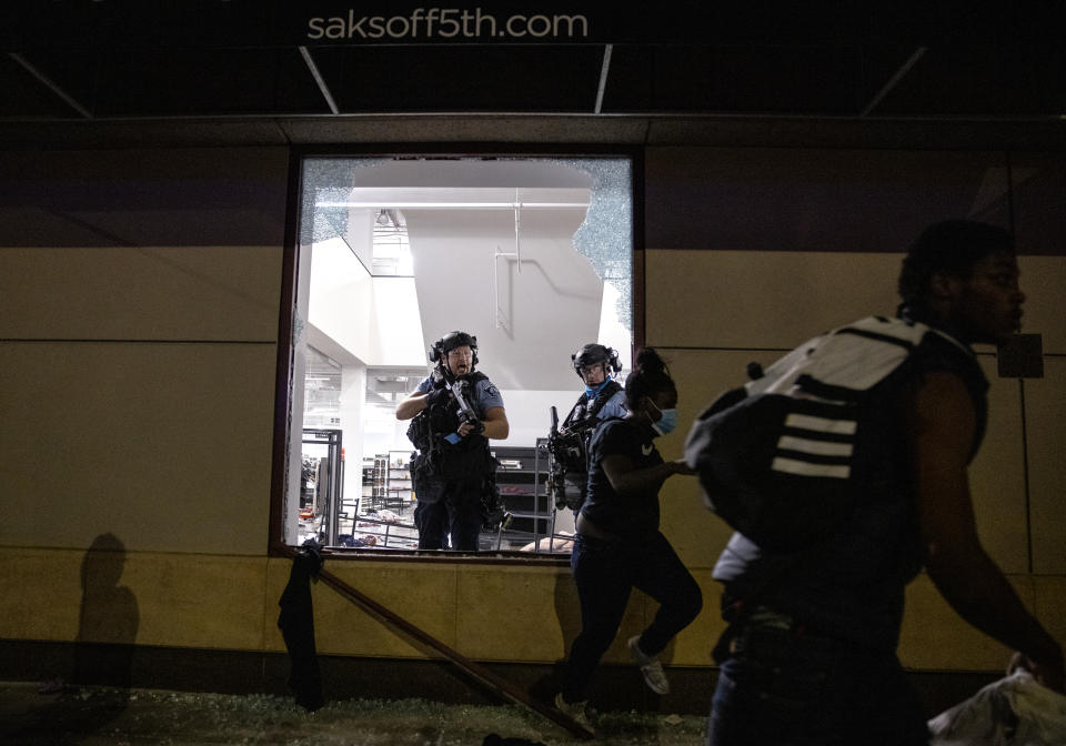 Police clear out and secure Saks OFF 5th Wednesday, Aug. 26, 2020 in Minneapolis. The Minneapolis mayor imposed a curfew Wednesday night and requested National Guard help after unrest broke out downtown following what authorities said was misinformation about the death of a Black homicide suspect. (Carlos Gonzalez/Star Tribune via AP)