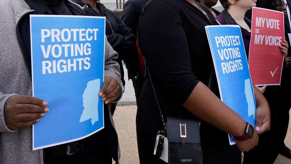 Members of voting rights group hold signs calling for protection of voting rights while joining others at a news conference in Jackson, Miss., Dec. 7, 2023.