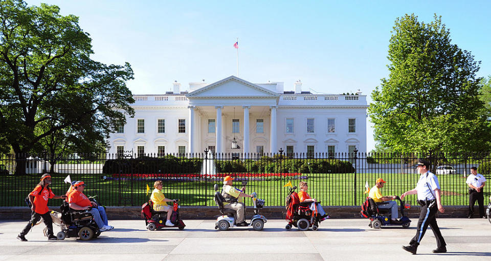 Members of ADAPT, a disability rights group pass the White House during a protest April 27, 2009 in Washington, DC. | KAREN BLEIER—AFP/Getty Images