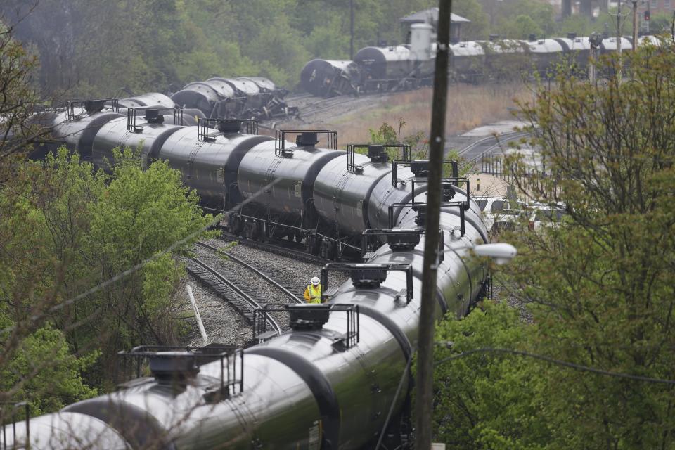 Firefighters and rescue workers work along the tracks where several CSX tanker cars carrying crude oil derailed and caught fire along the James River near downtown in Lynchburg, Va.., Wednesday, April 30, 2014. (AP Photo/Steve Helber)